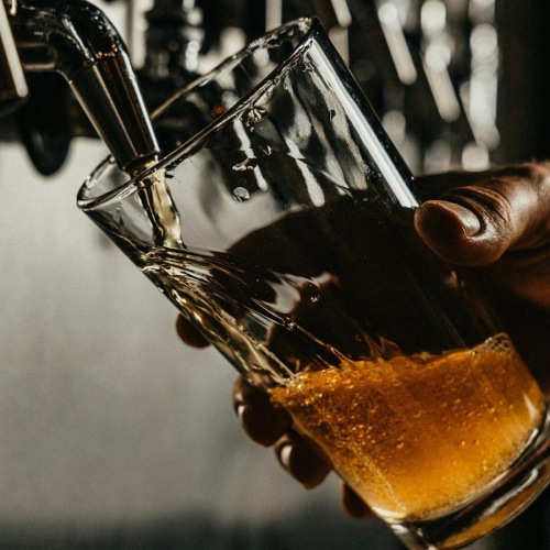 someone pouring a glass of beer